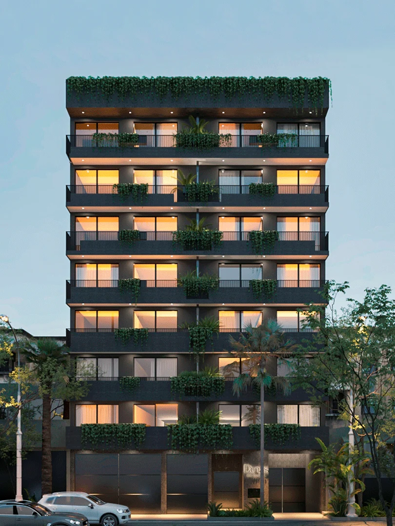 DUNAS Eje Central 909A tower at night, with balconies and planters.