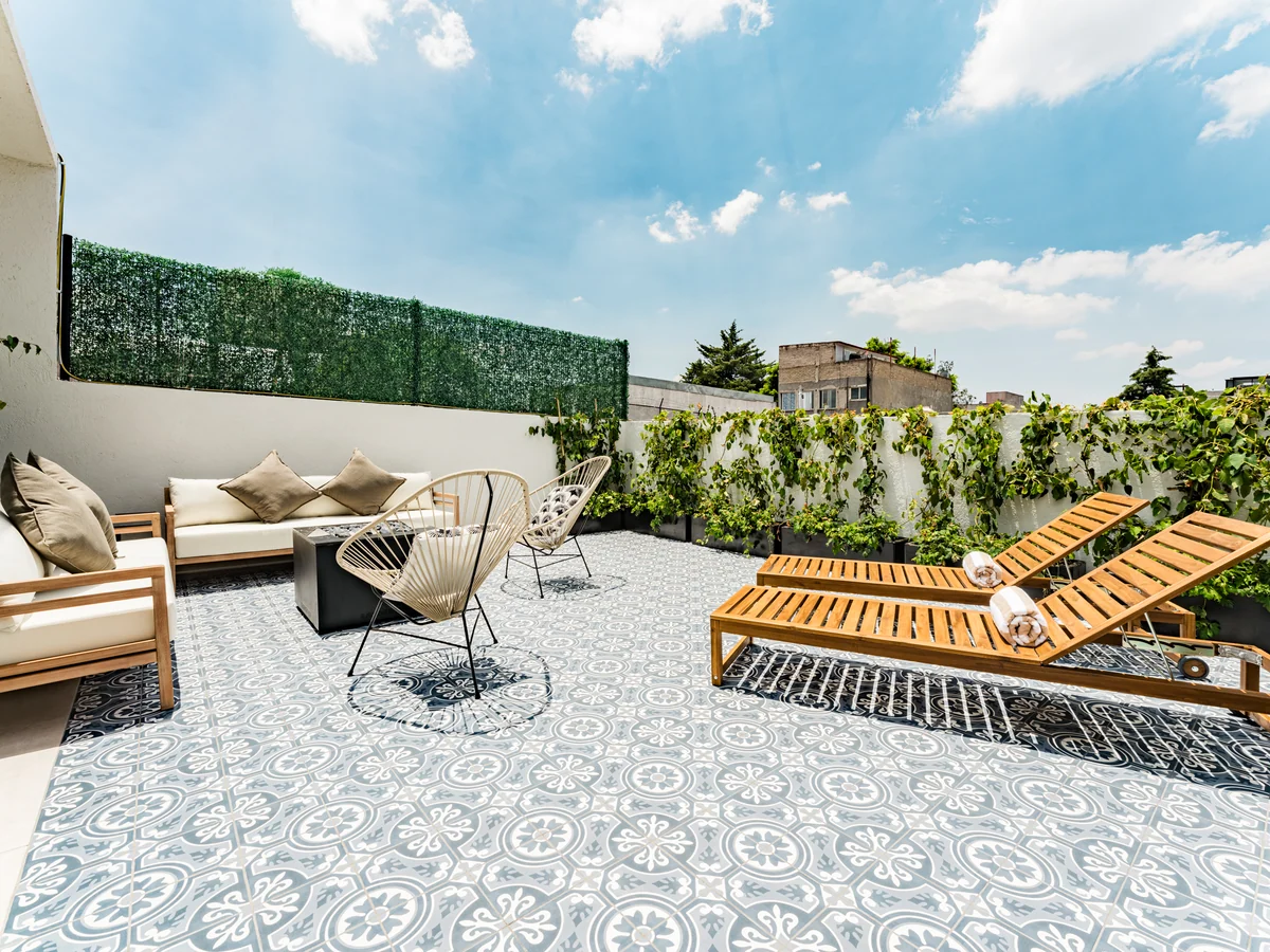 JA25, private project: roof garden with wooden loungers, cement tile floor and a green wall.