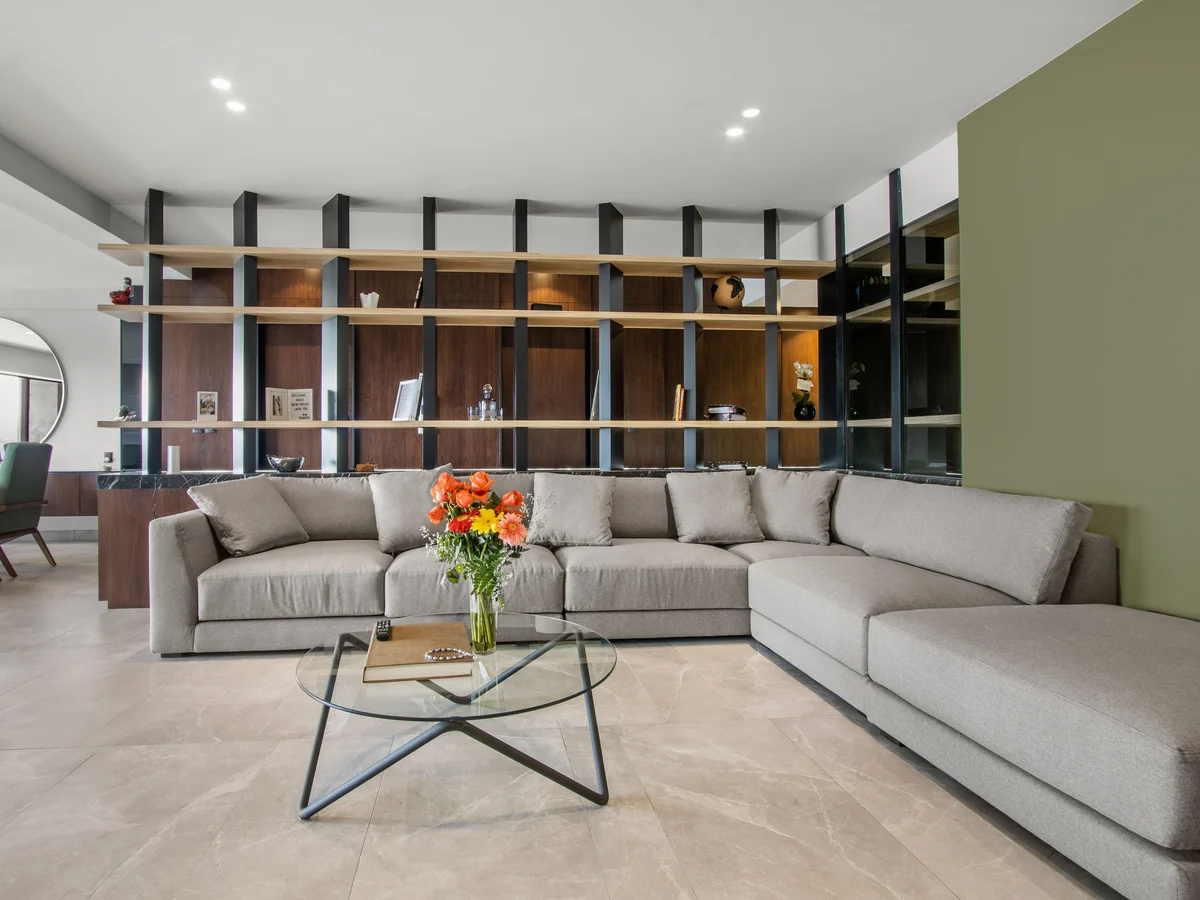 T1303, private project: living room with a steel and wood bookcase and an olive green wall.